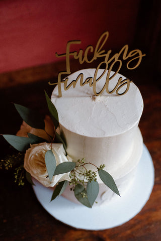 Fucking Finally - worth the wait wedding cake topper with live flowers decorating the cake