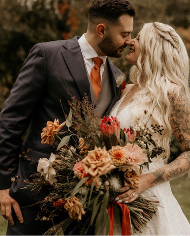 Image of bride holding an oversized bridal bouquet in fall colors