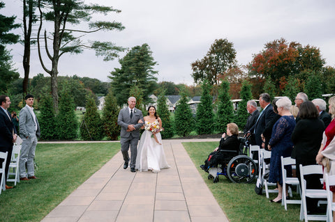 Image of bride and father of the bride walking down the aisle.