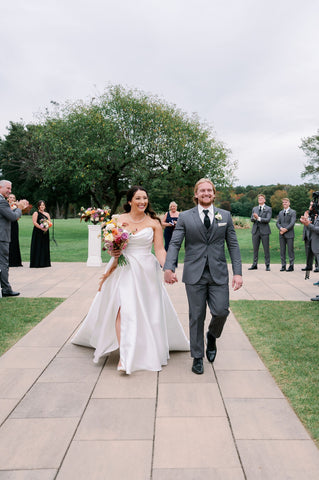 Image of bride and groom walking up the aisle at their outdoor wedding ceremony at the Cape Club of Sharon.