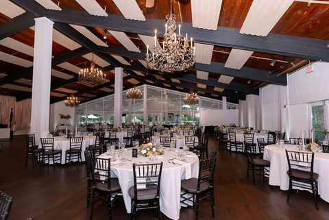 Image of wedding reception set up at the Cape Club of Sharon. The image shows the room all set up with white linens, centerpieces and table setttings.