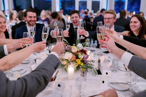 Image of wedding guests raising champagne glasses for toast.