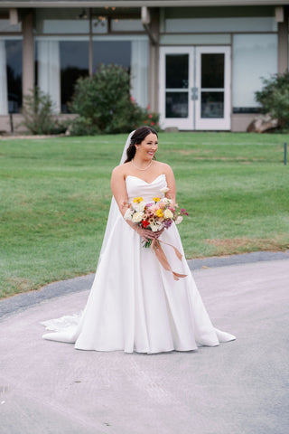 Image of bride smiling awaiting first look.