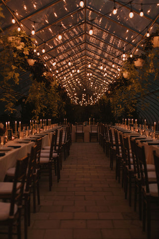 Herb Lyceum greenhouse reception space at night. Twinkle lights above.