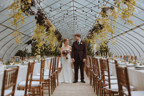 Wedding couple in their greenhouse at Herb Lyceum. Greenhouse is ready for reception with beautiful tablescapes.