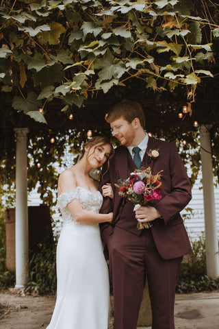 Bride and groom after outdoor wedding ceremony at the Herb Lyceum. Greenery overhead.