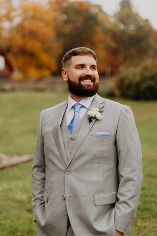 Picture of grrom in pale gray suit with white boutonniere