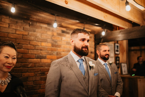 Image of groom seeing his bride walk down the aisle at their rustic elegant wedding at Westifled River Brewing Company