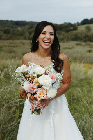 late summer floral bridal bouquet with timeless flowers and modern foliage including roses, dahlias, delphinium, dyed grevillea, rice flower, cress, and thistle