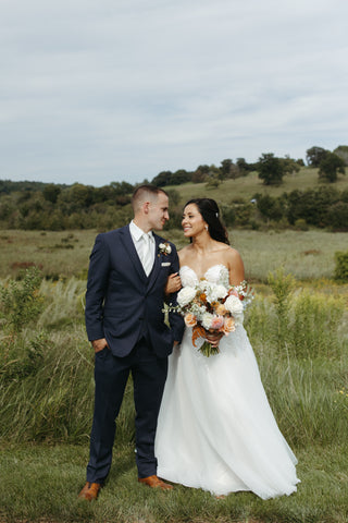 late summer bridal bouquet with timeless flowers and modern foliage including roses, dahlias, delphinium, dyed grevillea, rice flower, cress, and thistle