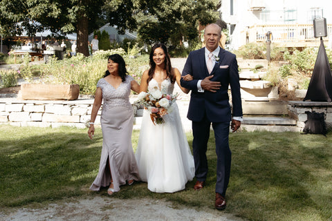 late summer floral wedding arbor with timeless flowers and modern foliage including roses, dahlias, delphinium, dyed grevillea, rice flower, cress, and thistle