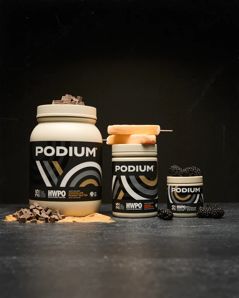 Podium protein supplements with chocolate, blackberries, and orange popsicles displayed on a dark background.