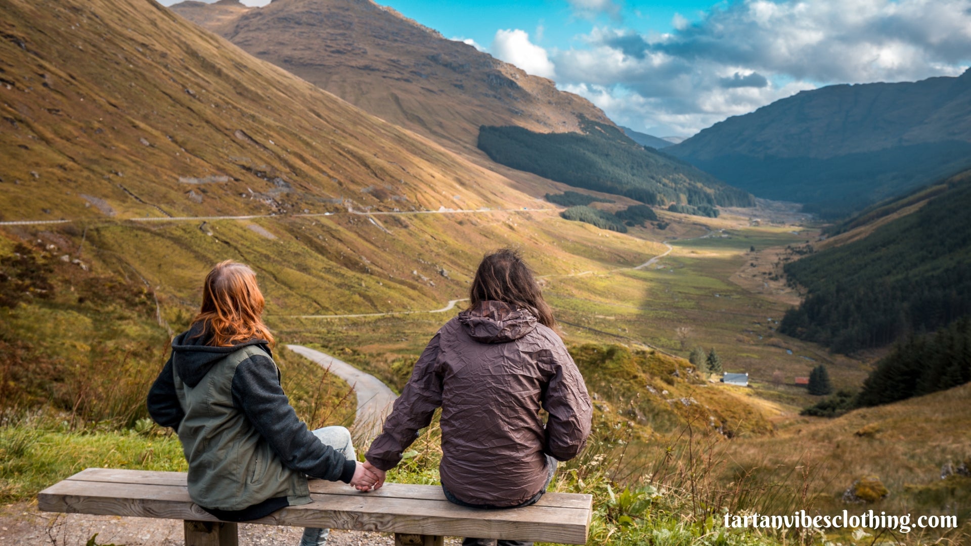 Couple holding hands and overlooking view of Scottish mountains