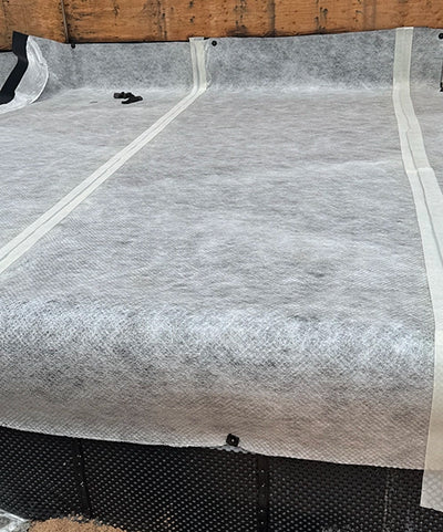 Taping the seams of SUPERSEAL Double Drain with SUPERSEAL Waterproofing Tape