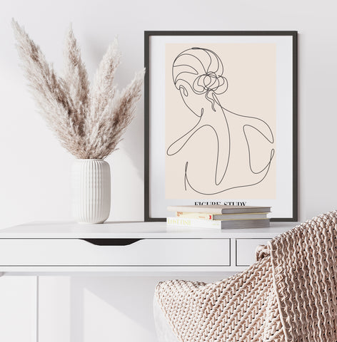 Neutral and black abstract line wall art of a female silhouette from the black in black frame in a neutral home office.  