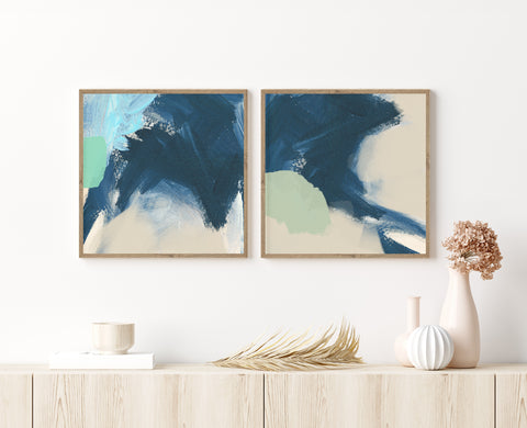 Set of 2 blue and neutral abstract wall art pictured in a neutral living room. 