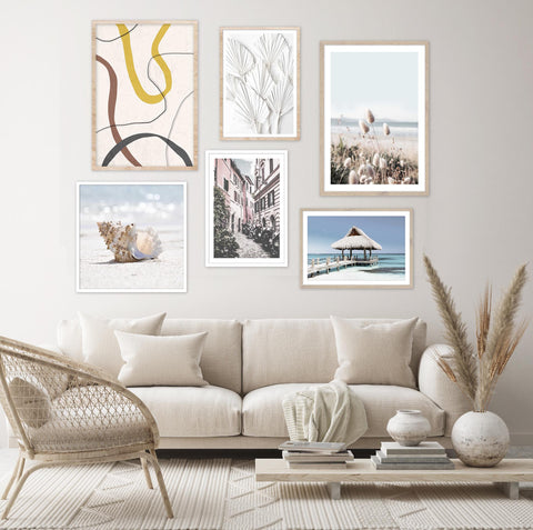 Beach photography wall art gallery wall pictured in a neutral living room. 