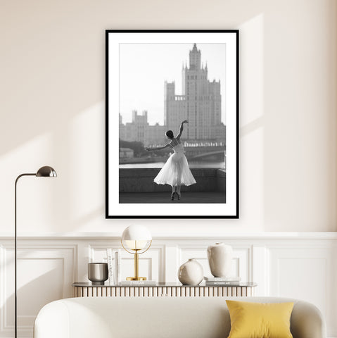 Beautiful black and white photography wall art of a ballerina dancing in New York. Pictured in a neutral living room. 