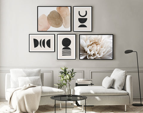 Geometric black, white and neutral abstract wall art gallery wall with neutral abstract and floral photography. Pictured in a neutral living room. 