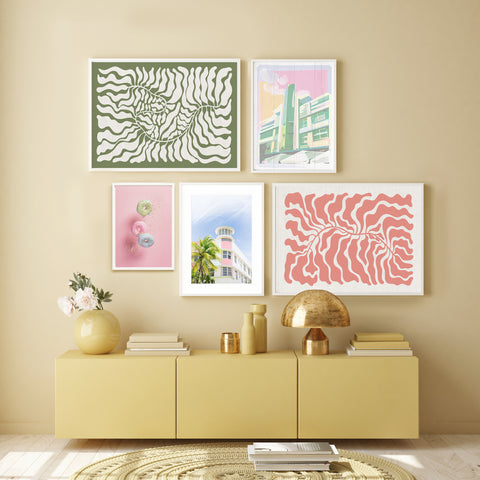 Colourful gallery wall with green and pink abstract wall art and pictured in a yellow bedroom. 