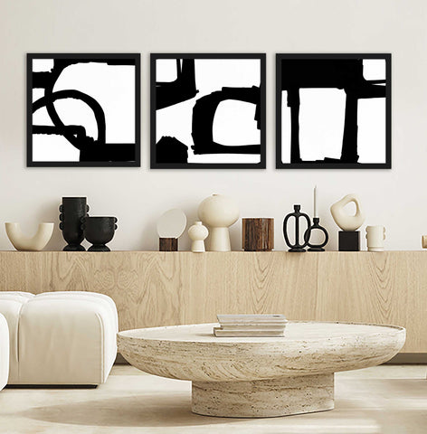 Set of 3 black and white abstract wall art pictured in a neutral living room. 