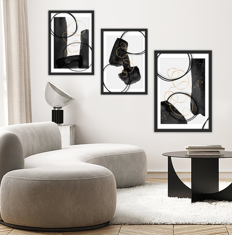 Set of 3 gold, black and white abstract wall art pictured in a grey and neutral living room. 
