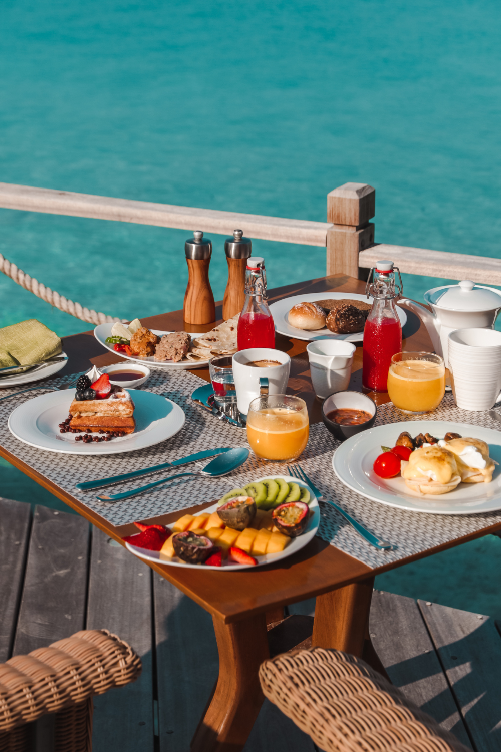 Table set with breakfast for two by water in Maldives