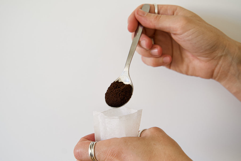 Filling biodegradable tea bag with coffee grounds