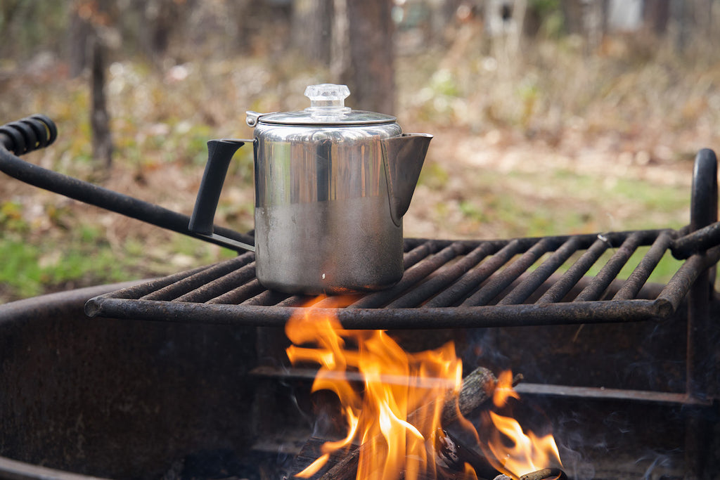 Percolator heating water over a campfire