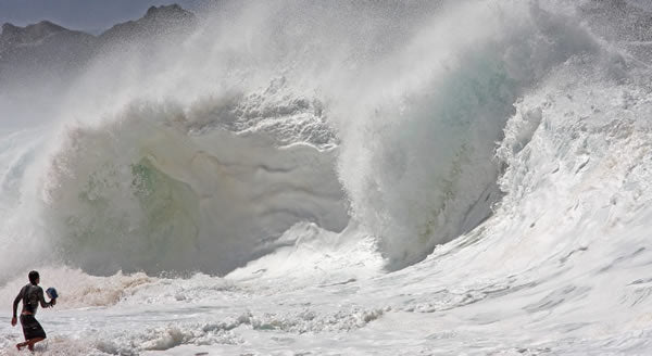 Clark Little running towards large wave on shore