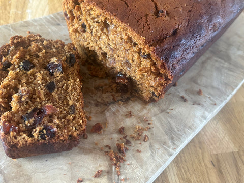 Sliced chocolate tea loaf cake, a honey brown coloured loaf cake with dried fruit within the sponge. 