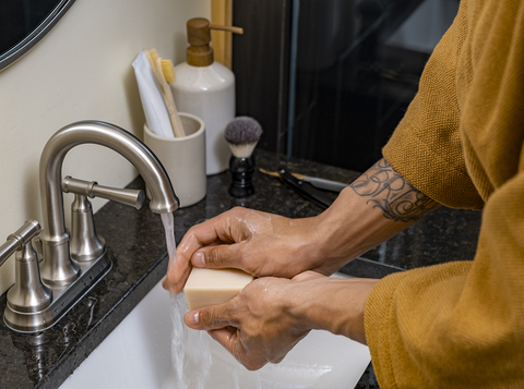 Mans hands washing with a Man Bar Mini at the sink