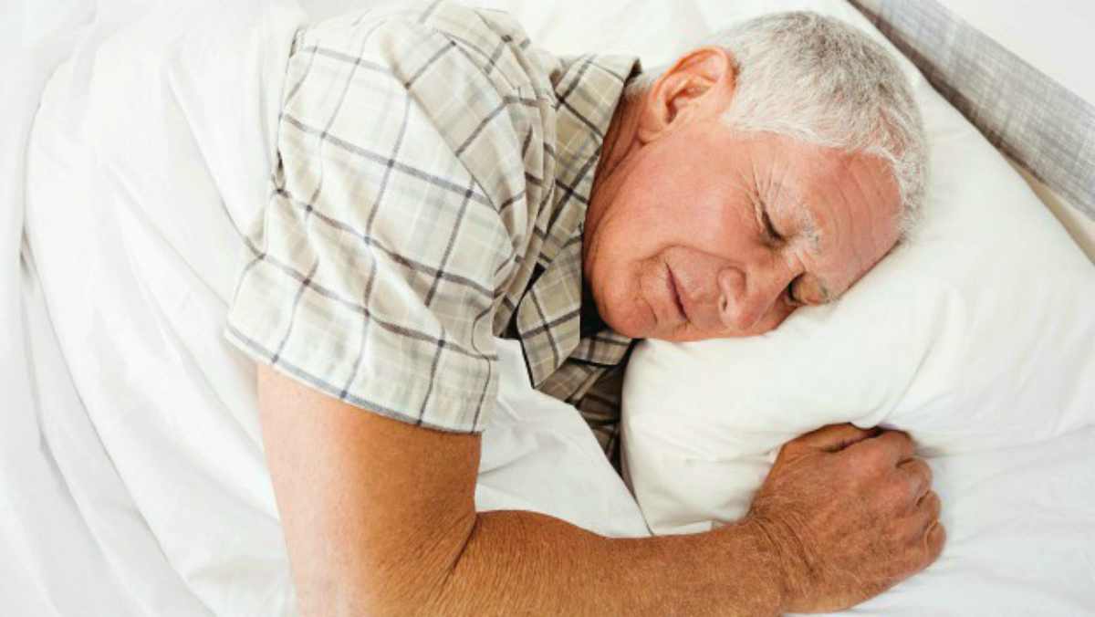 Senior man sleeping on bed in bedroom