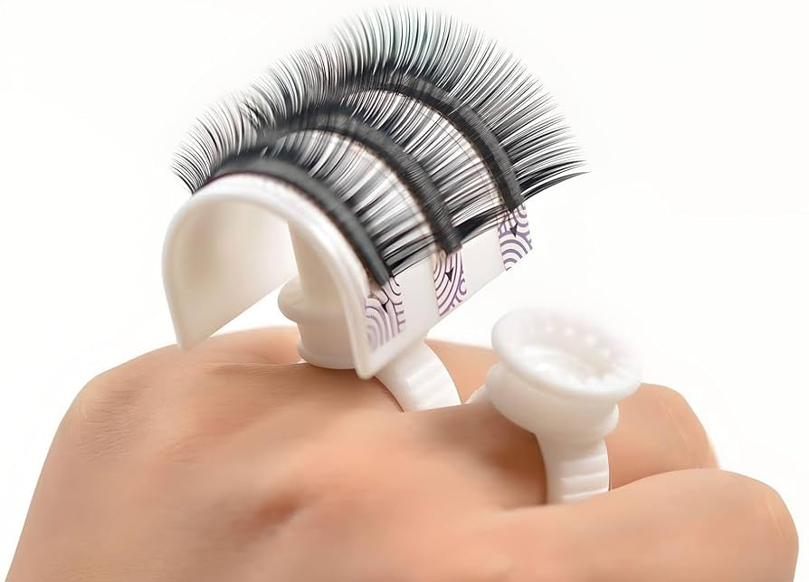 a palette ring, a wearable lash supplies typically worn on the finger, designed to hold and dispense small amounts of beauty products like lash glue or pigment during cosmetic procedures. This tool offers convenience and accessibility for precise application in beauty treatments
