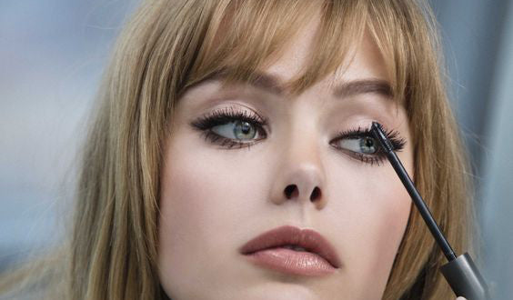 Lash care tip 2: Beware the static. A woman brushing her eyelashes with a specialized lash extension-friendly soft brush to keep them looking fluttery and fabulous, preventing clumping and static during winter.