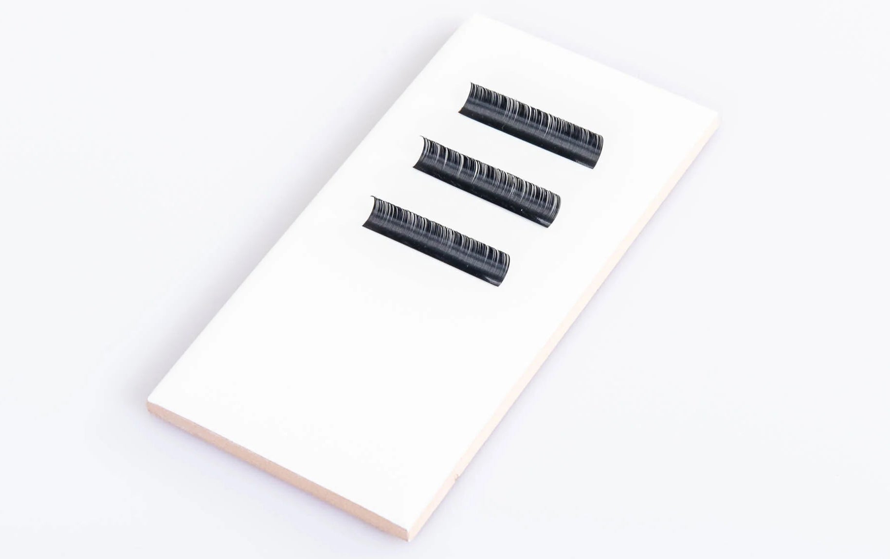 A blank lash tile, offering a pristine white surface ideal for maximum customization by lash artists. This featureless tile provides a clean canvas for organizing lash extensions, allowing personalized arrangement and organization based on individual preferences and needs