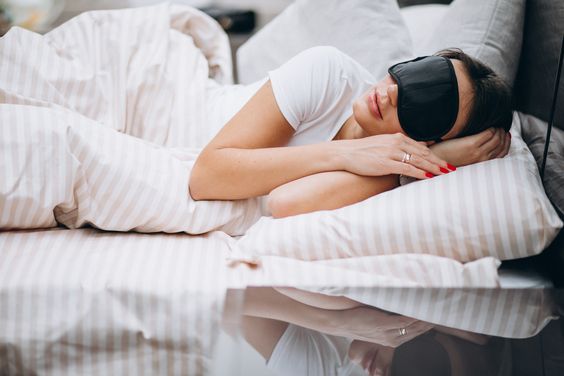 An image of a woman peacefully sleeping with her sleep mask and using a soft, lash-friendly pillow as part of her lash aftercare routine, ensuring the longevity of her eyelash extensions