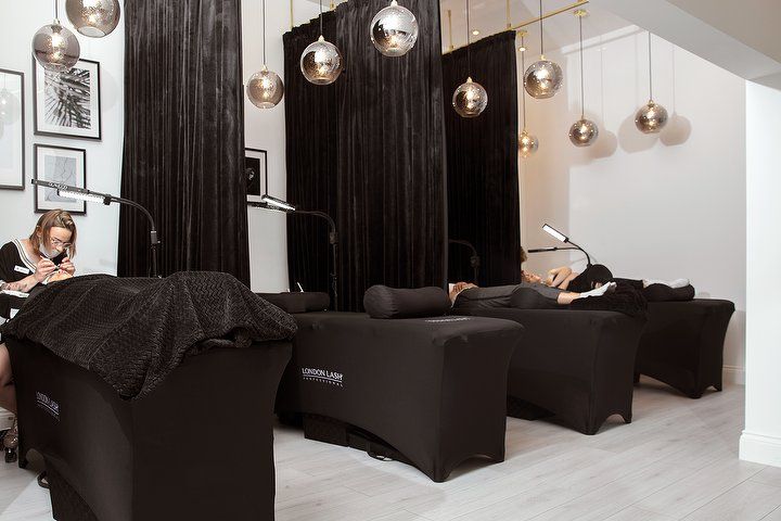 London Lash interior design featuring a cozy corner adorned in rich black tones and silver accents. The ambiance exudes warmth, luxury, professionalism, and elegance, reflecting the brand's image