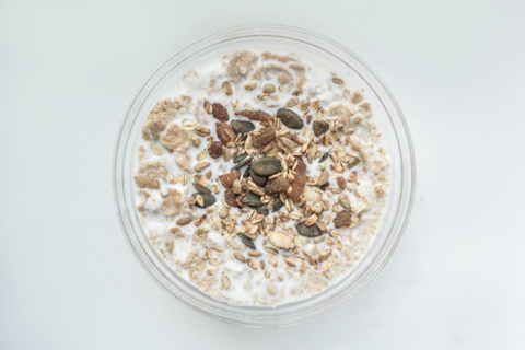 a bowl of oatmeal with seeds sprinkled on top