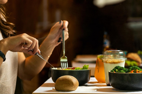 woman eating a salad with lemon water pictured