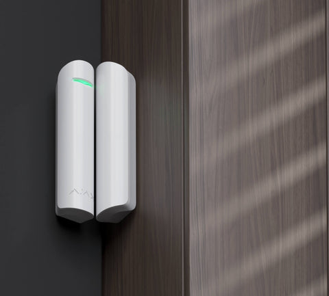 Ajax wireless door alarm sensor installed indoor.