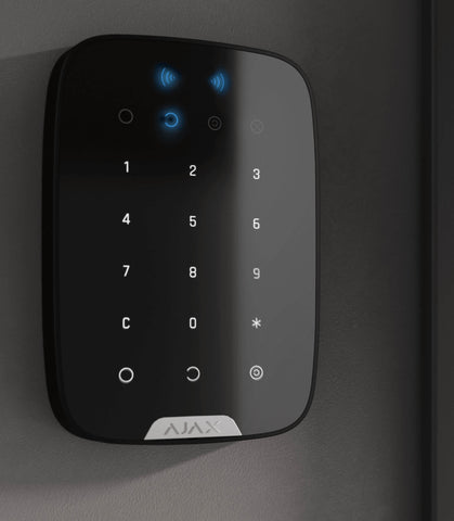 Ajax KeyPad Plus mounted to a wall, showcasing its sleek design and intuitive interface for easy arming and disarming of a home or business security system.