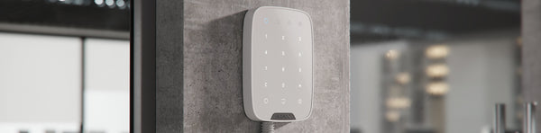 White Ajax KeyPad Plus with functional elements, mounted on a wall. 