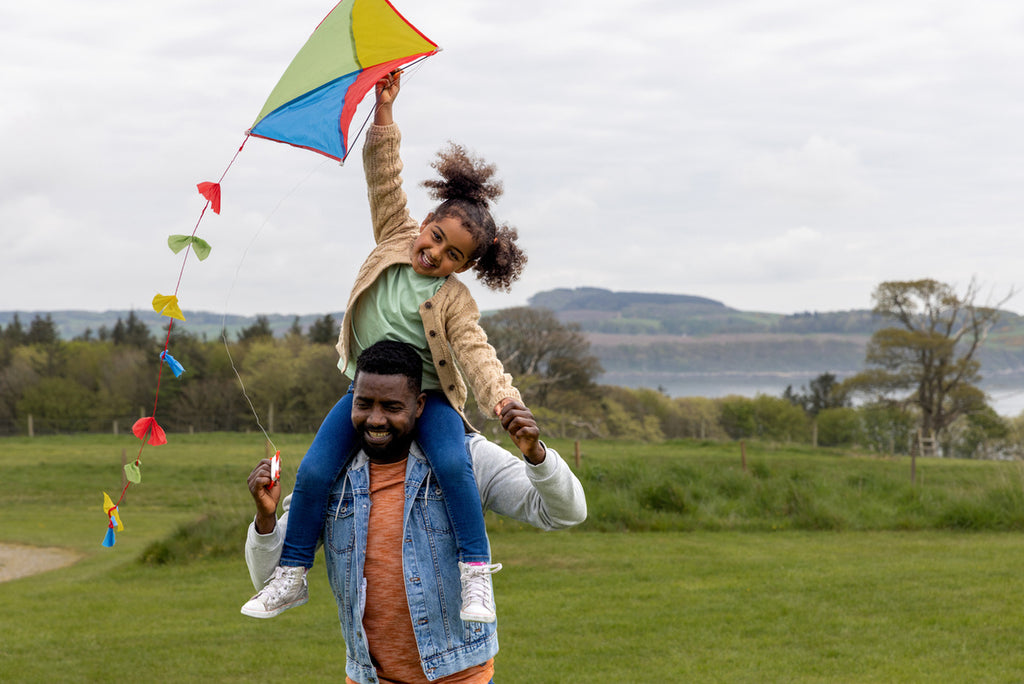 dad and daughter flying a kite together
