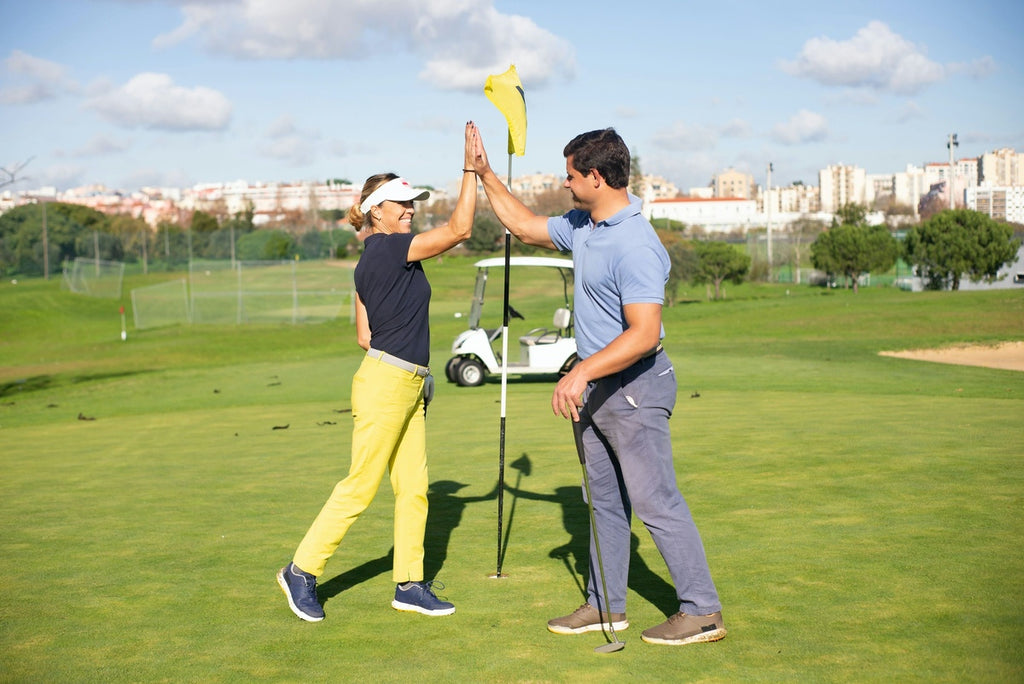 couple high fiving on golf course