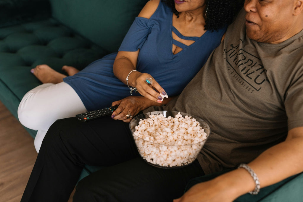 couple eating popcorn on sofa