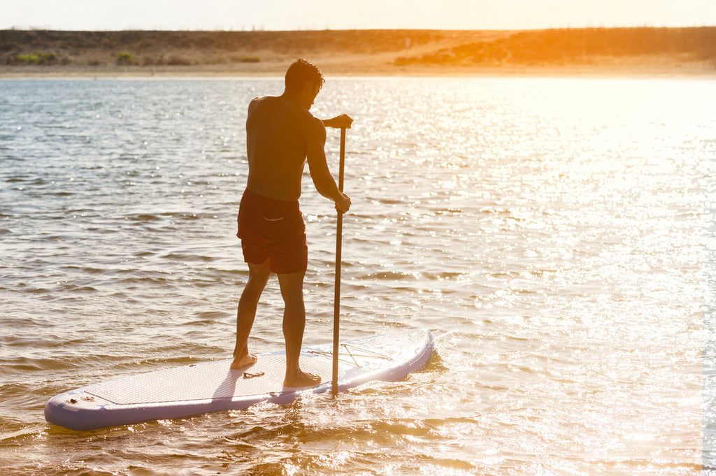 man on paddleboard in the sunset
