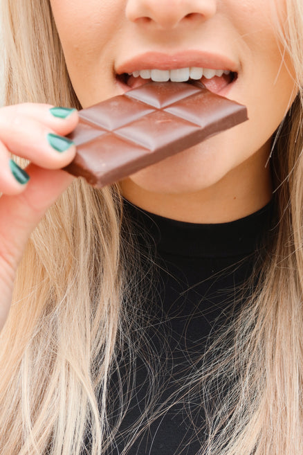 Girl bitting Macalat Sweet Dark Chocolate bar