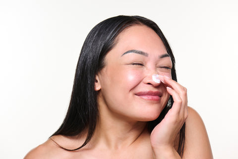 woman applying mineral sunscreen to nose