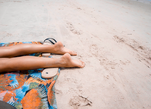 sunbathing legs on sandy beach